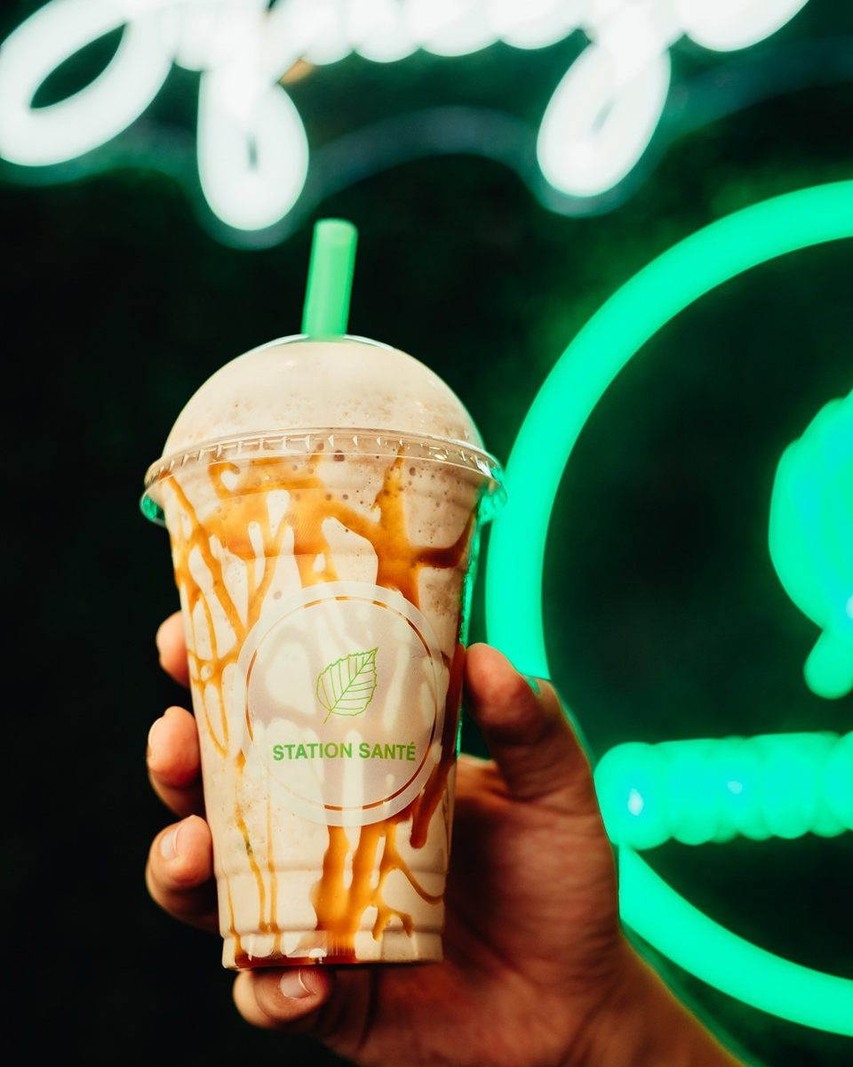 Station Santé caramel protein shake in front of the neon sign